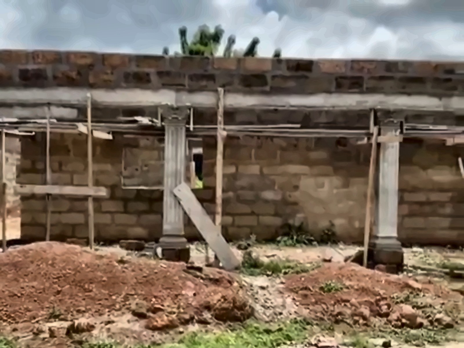 Front of the new health centre with columns and timber scaffolding